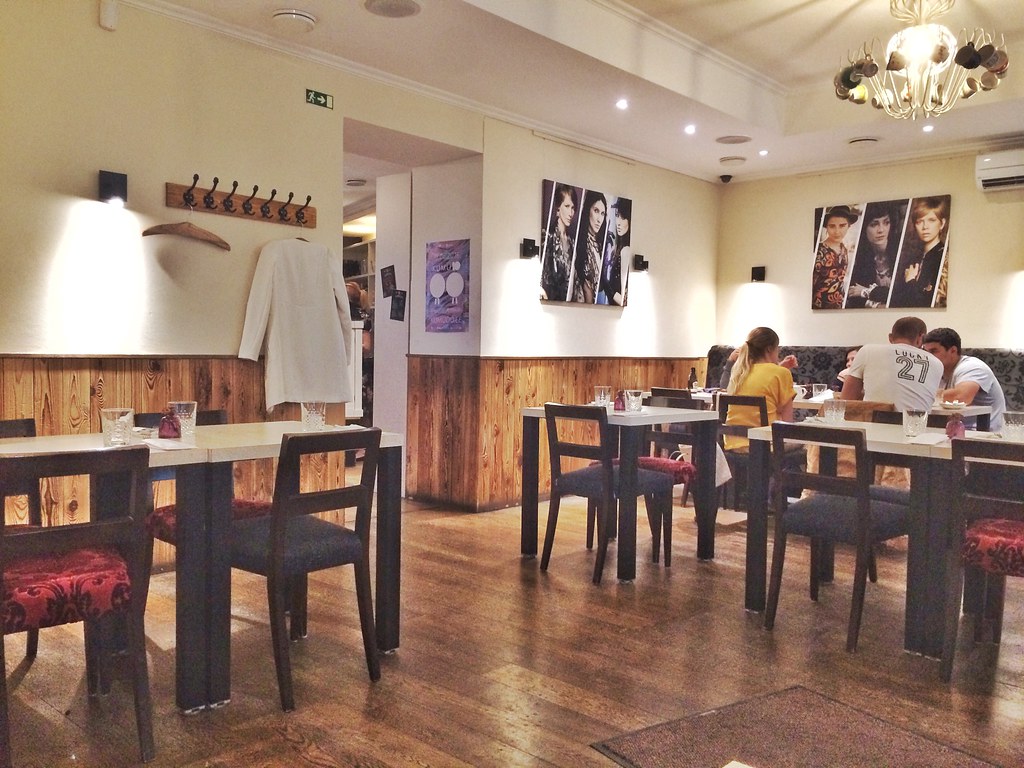 Interior acogedor del restaurante Kohvik Moon con comensales y decoración contemporánea.
